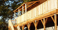 Custom second story cedar deck with covered area and egress stairs.